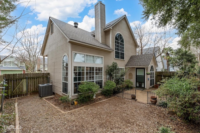 back of property featuring roof with shingles, a chimney, fence, and central air condition unit