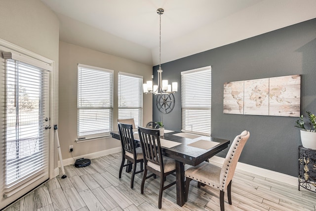 dining space with baseboards, a notable chandelier, and wood finish floors