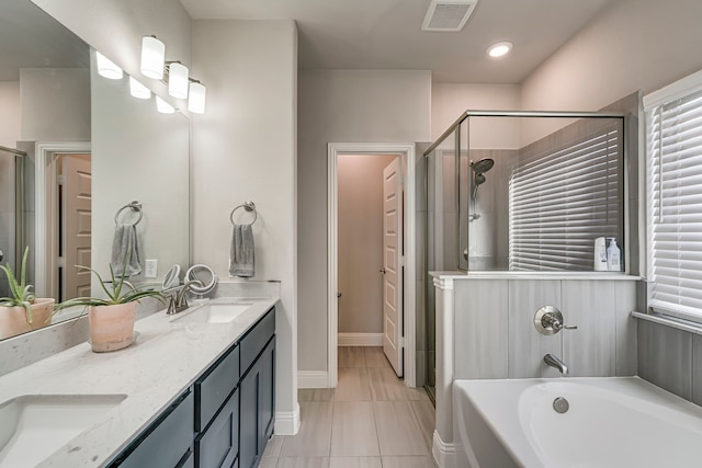 bathroom with a sink, a garden tub, a shower stall, and visible vents