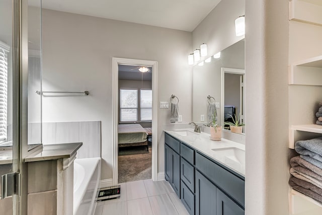 bathroom with double vanity, a sink, a bath, and ensuite bathroom