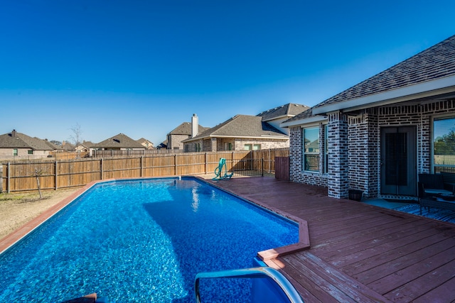 view of pool with a fenced backyard, a residential view, a fenced in pool, and a wooden deck