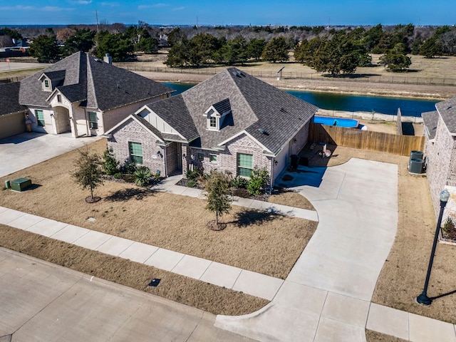 view of front facade with roof with shingles and fence