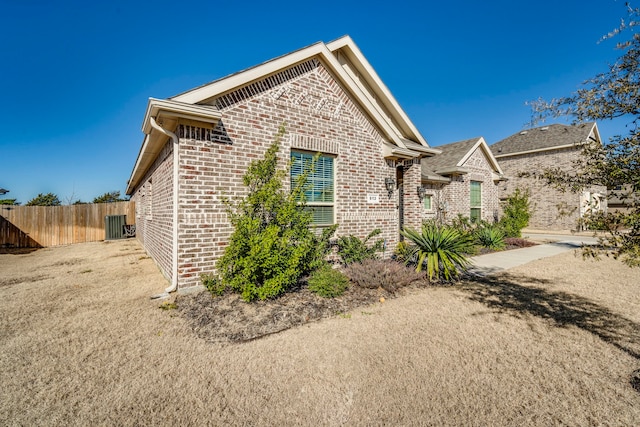 view of front of home featuring fence and brick siding