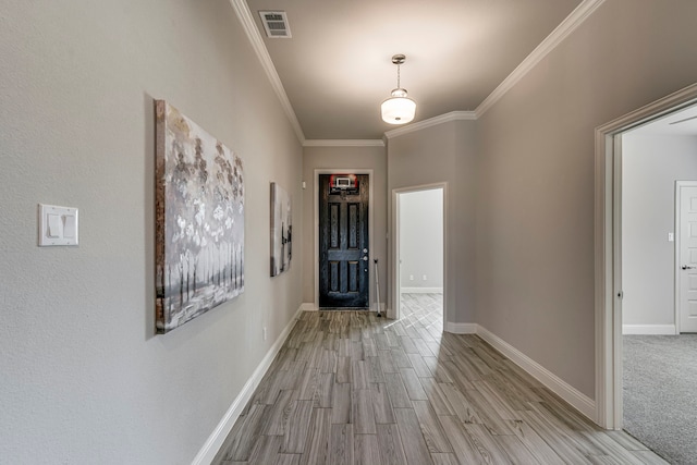 entrance foyer with light wood-style floors, baseboards, visible vents, and ornamental molding