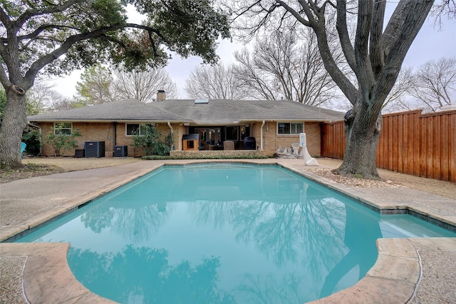 view of swimming pool with a fenced in pool, fence, and central air condition unit