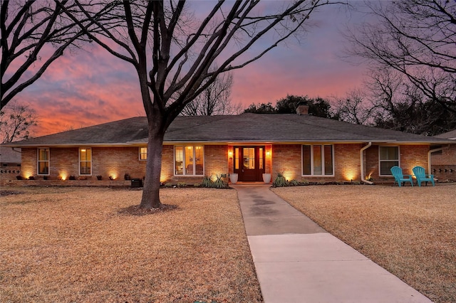 single story home with brick siding and a chimney