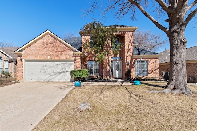 traditional-style home featuring an attached garage, driveway, and brick siding