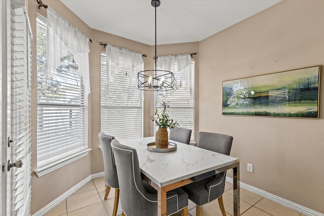 dining area featuring a wealth of natural light, light tile patterned flooring, and a textured ceiling