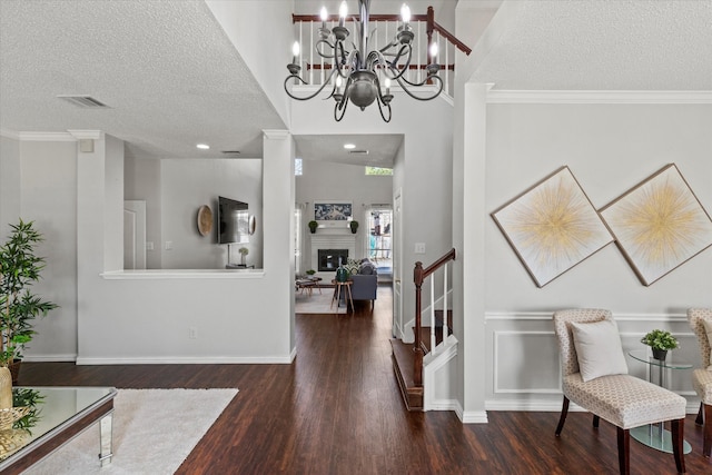 entryway featuring a textured ceiling, crown molding, a fireplace, and wood finished floors