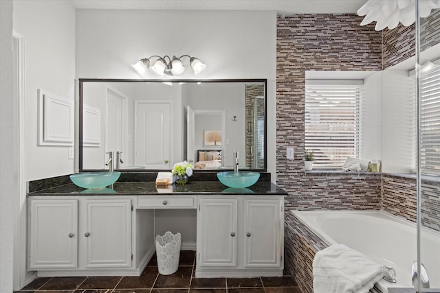 full bath with double vanity, a garden tub, tile patterned flooring, and a sink