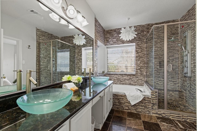 full bath with double vanity, a stall shower, visible vents, a garden tub, and a sink