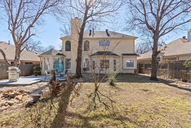 rear view of house featuring a yard, a fenced backyard, a chimney, and a patio