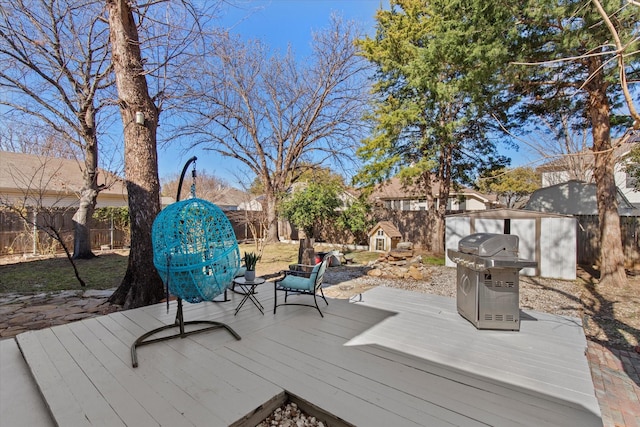 wooden terrace featuring area for grilling and a fenced backyard