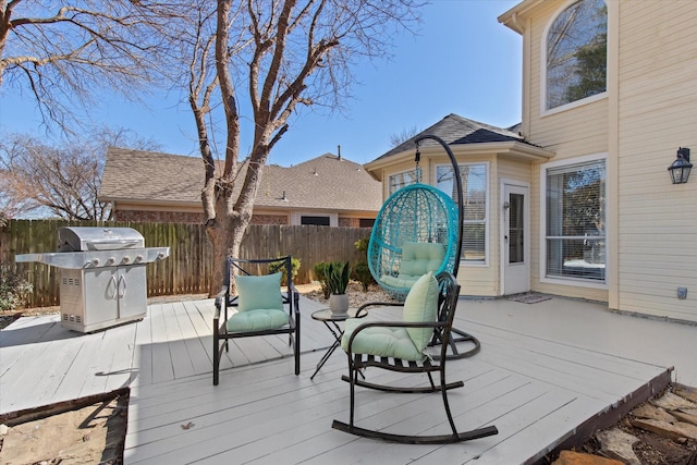 wooden deck with a grill and fence