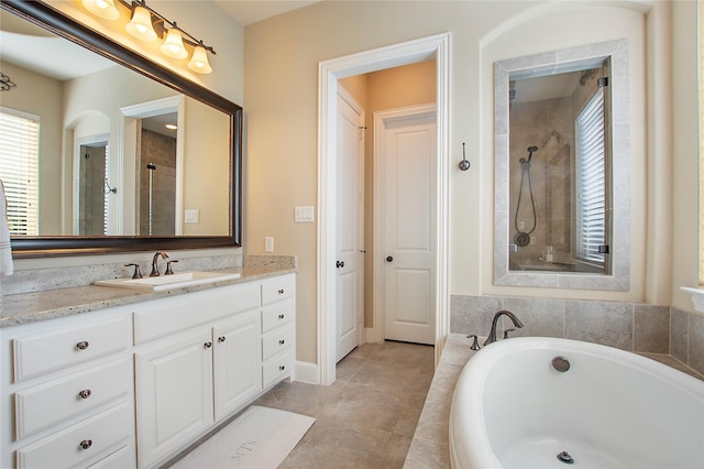 bathroom with a tub, a tile shower, and vanity