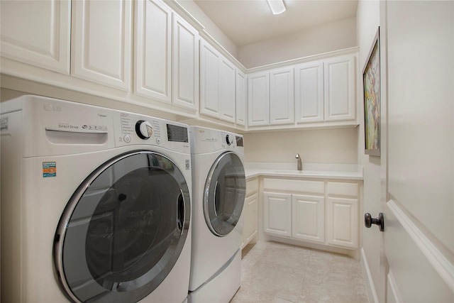 laundry room featuring a sink, cabinet space, light tile patterned floors, and washer and dryer