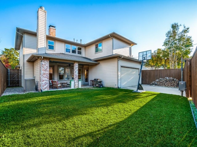 back of house with a garage, a yard, a patio area, and a fenced backyard