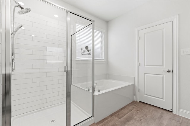 full bath with wood finished floors, a shower stall, and a bath