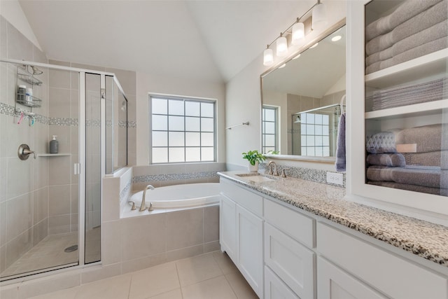 full bathroom featuring tile patterned flooring, a garden tub, vaulted ceiling, and a shower stall