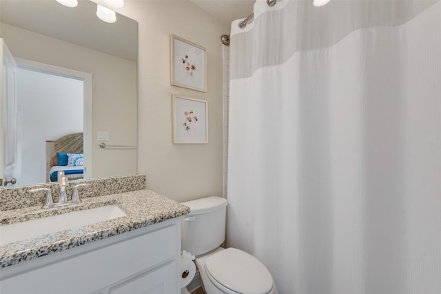 ensuite bathroom featuring a shower with curtain, vanity, toilet, and connected bathroom