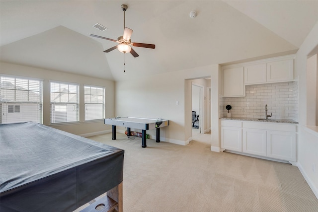 game room featuring lofted ceiling, ceiling fan, light carpet, visible vents, and baseboards