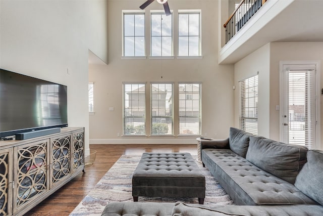 living area with ceiling fan, wood finished floors, and baseboards