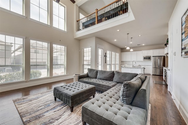 living room with recessed lighting, baseboards, and wood finished floors