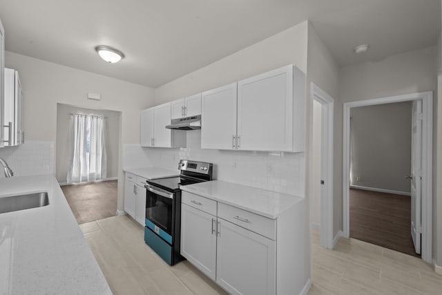 kitchen with light countertops, electric range, a sink, and under cabinet range hood