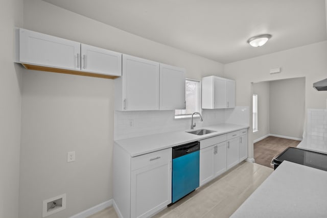 kitchen with a sink, white cabinets, light countertops, decorative backsplash, and dishwasher