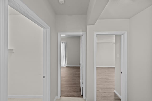 hall with wood finished floors and baseboards