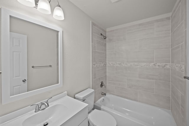 bathroom featuring toilet, a textured wall,  shower combination, and vanity