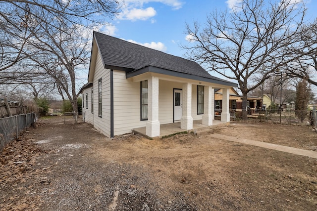 view of front of property with a shingled roof and fence