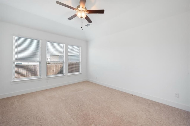 empty room with light colored carpet, ceiling fan, visible vents, and baseboards