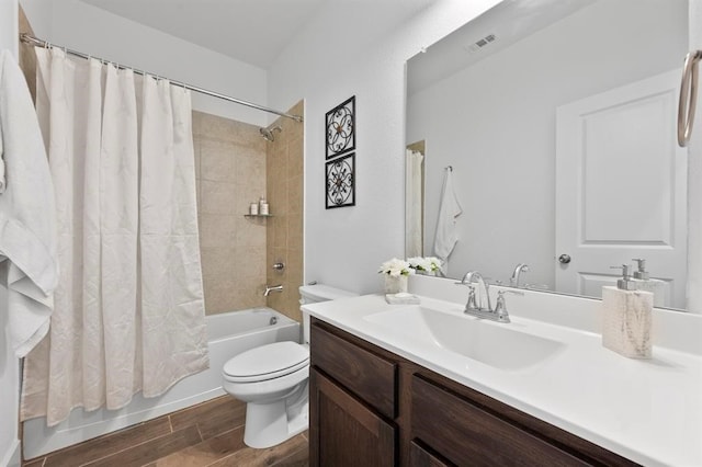 full bathroom featuring shower / tub combo, visible vents, toilet, wood tiled floor, and vanity