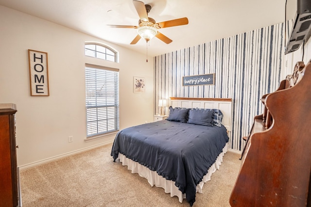 bedroom with light colored carpet, ceiling fan, and baseboards