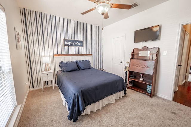 carpeted bedroom with baseboards, visible vents, and a ceiling fan