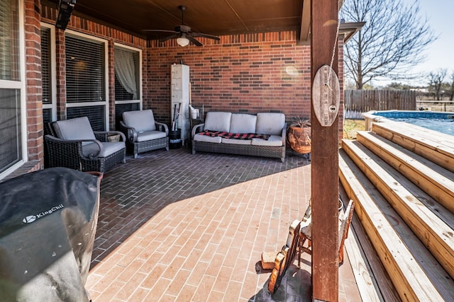 view of patio featuring an outdoor hangout area, a grill, a ceiling fan, fence, and a fenced in pool