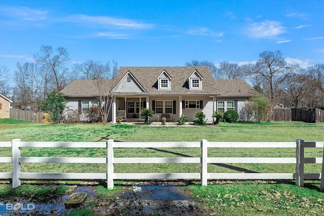 new england style home featuring a fenced front yard and a front yard