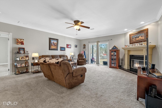 living room with carpet, visible vents, ornamental molding, a glass covered fireplace, and a ceiling fan