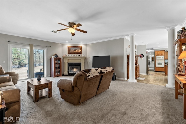 living room featuring light carpet, visible vents, ornamental molding, a glass covered fireplace, and ornate columns