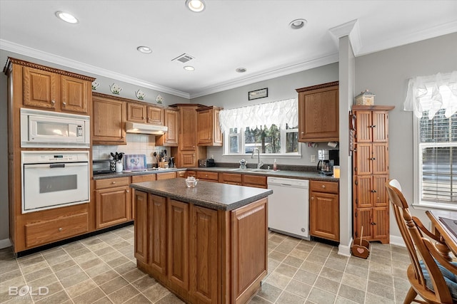 kitchen featuring white appliances, dark countertops, visible vents, and under cabinet range hood