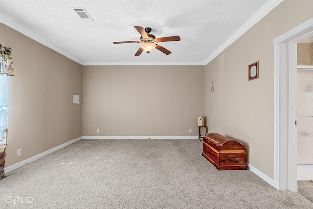 spare room with carpet floors, visible vents, a textured ceiling, and ornamental molding