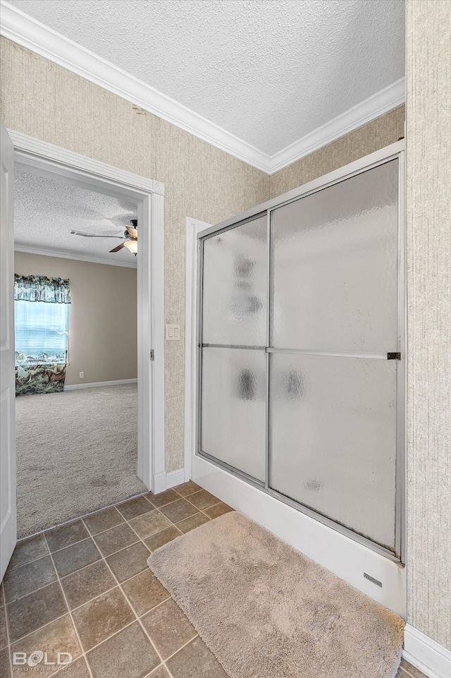 bathroom with a ceiling fan, a textured ceiling, an enclosed shower, and crown molding