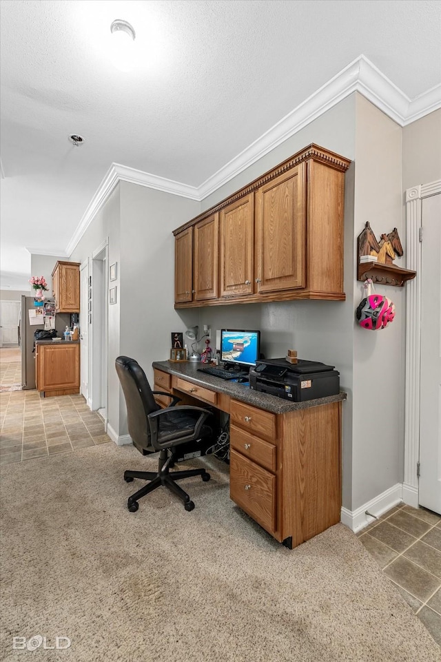 home office with crown molding, light tile patterned floors, light colored carpet, built in study area, and baseboards