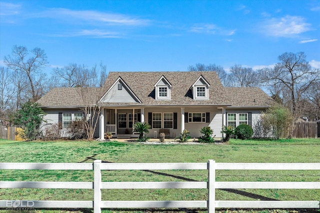 cape cod home featuring a front lawn, a fenced front yard, and a shingled roof