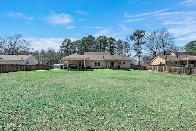 back of house featuring a fenced backyard and a lawn