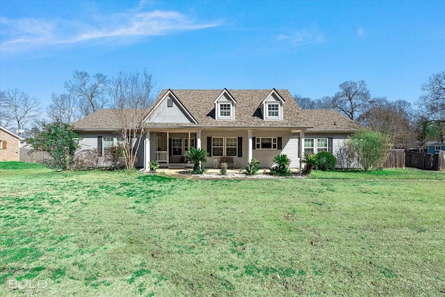 view of front facade with covered porch, a front lawn, and fence