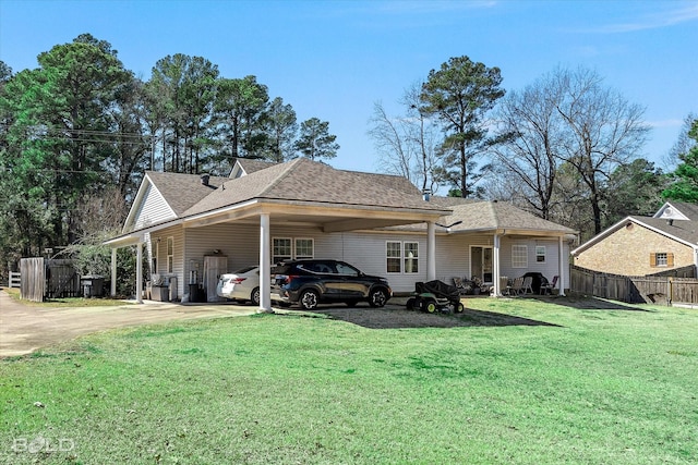 view of front of house with a shingled roof, fence, a carport, driveway, and a front lawn