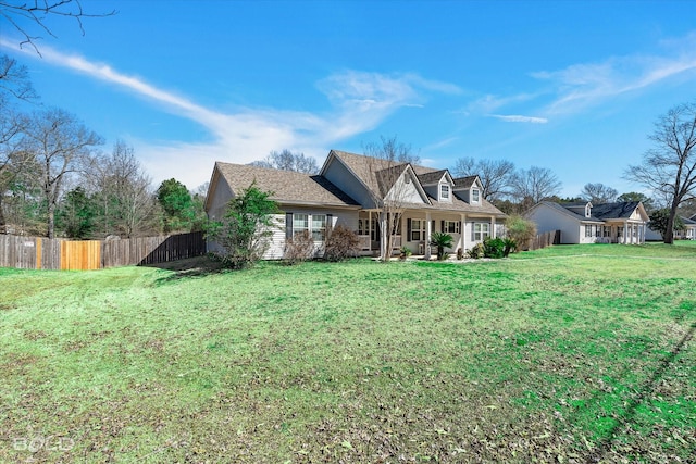 back of property featuring fence and a yard