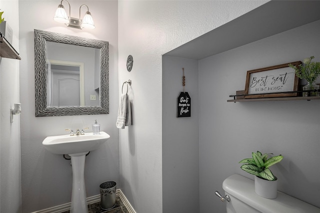 half bathroom with toilet and baseboards